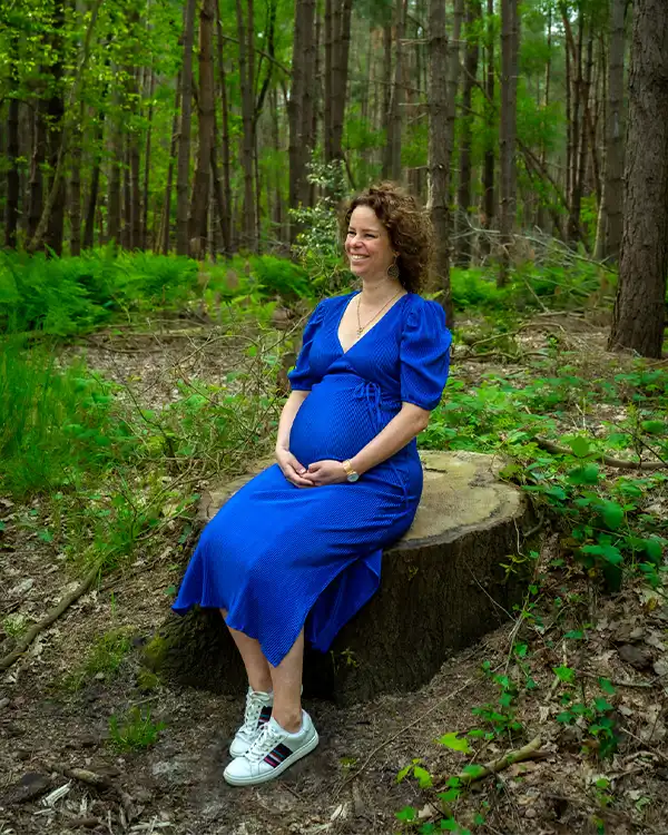 Zwangere vrouw in zittend in het bos
